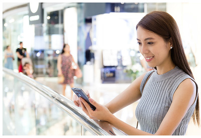 Chinese young woman using smartphone at mall